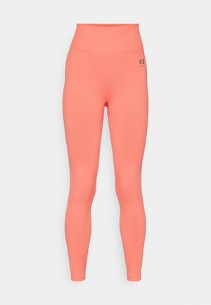 Augstās jostasvietas legingi spožā korallā, izgatavoti no elastīga auduma. Ievērojama gluda tekstūra un neliels melns logotips jostasvietā.