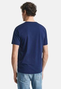 Navyblauwe T-shirt met korte mouwen van katoen, met een ronde halslijn en een relaxte pasvorm. De achterkant heeft een gladde textuur.