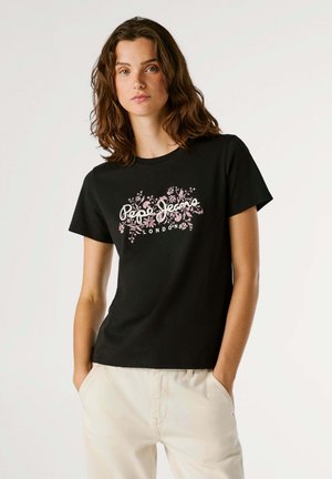 T-shirt en coton noir avec un imprimé graphique floral en rose et blanc, texte "Pepe Jeans London", manches courtes et col rond.