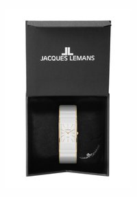 Reloj rectangular blanco con acentos dorados, alojado en una caja negra con un interior suave. Presenta una esfera minimalista y una correa texturizada.