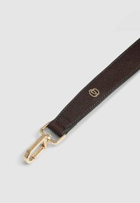 Bruine leren band met een gestructureerde afwerking en metalen hardware in goudkleur. Voorzien van een clip om vast te maken en een logo-accent.