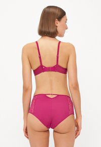 Fuchsia lingerie set met een beha met verstelbare bandjes en een bijpassende high-waisted slip. De slips hebben kanten zijkanten en een decoratieve achterkant.
