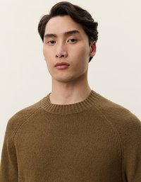 Καφέ πλεκτό πουλόβερ με ριμπ λαιμόκοψη, διαθέτει χαλαρή εφαρμογή και ραγλάν μανίκια, υφαντή επιφάνεια και μέτρια πάχυνση.