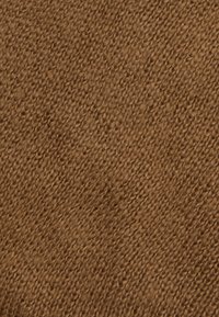 Zbliżenie brązowej dzianiny pokazujące szczegółową teksturę ściegów i miękkie włókna przędzy.