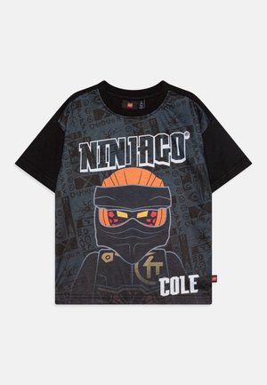 Camiseta negra y gris con un personaje de Ninjago, con detalles en naranja y el texto "NINJAGO COLE." La tela tiene una textura suave.