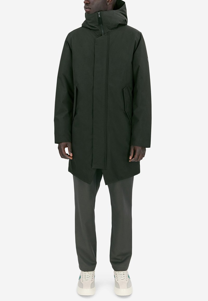 Mörkgrön huva med dragsko, framzip, två sidofickor och rak skärning. Tyget är slätt med en matt yta.