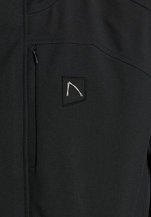 Black softshell jacket with a textured finish, featuring a zippered chest pocket and a small white embroidered logo on the upper left side.
