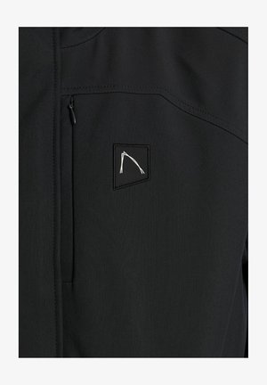 Czarna kurtka softshell o teksturowym wykończeniu, z zamykaną na zamek kieszenią na piersi i małym, białym wyhaftowanym logo na górnej lewej stronie.