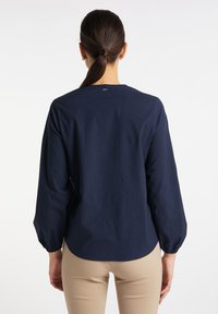Marineblå langærmet skjorte med rund halsudskæring og rynkede manchetter. Bl�ødt, glat stof med en let buet kant og minimal branding bagpå.