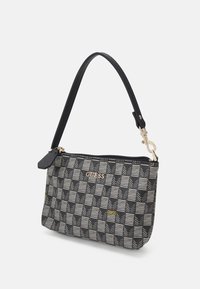 Petit bracelet rectangulaire noir et gris à motif avec fermeture éclair, sangle noire amovible et logo doré "GUESS" sur le devant.