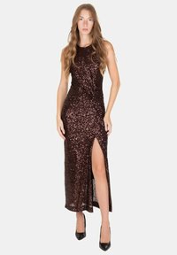 Abito da sera marrone con paillettes, dotato di un lungo spacco, design senza maniche e dettaglio a torsione in vita. Tacchi alti neri completano l'outfit.