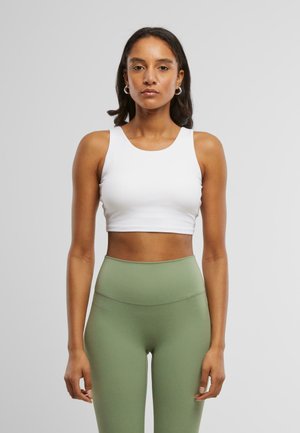 Witte, cropped sporttanktop met een ronde halslijn, gecombineerd met hooggesneden, gestructureerde olijfgroene legging.