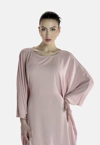 Helles rosa Kleid aus weichem Stoff, mit lockerer Passform, weiten Fledermausärmeln und Rundhals-Ausschnitt, das eine leichte Textur aufweist.