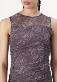 Μωβ αμάνικο φόρεμα με διάφανα υφάσματα, που διαθέτει υφαντό υλικό με σπειροειδή σχέδια και μαζεμένο λεπτό σχέδιο κατά μήκος των πλαινών.