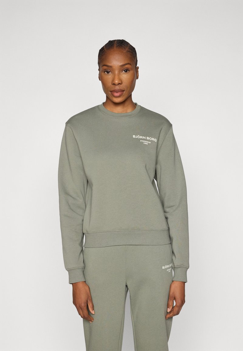 Ανοιχτό πράσινο φούτερ από μαλακό ύφασμα, με στρογγυλή λαιμόκοψη, μακριά μανίκια, ριμπ μανσέτες και το λογότυπο "BJÖRN BORG" στο στήθος.