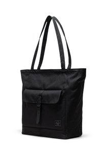 Borsa a spalla nera in tela con una base larga, manici lunghi, tasca frontale con patta sicura tramite un cinturino e una piccola etichetta con logo.