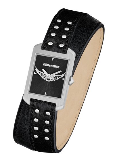 Pravokotni srebrni ročni ura s črnim zaslonom, na katerem so krilate kazalke za ure in minute, združena s črnim usnjenim paščkom, okrašenim s srebrnimi žebljiči.