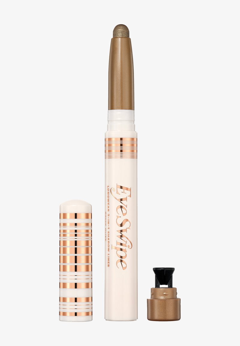 Kremowy cień do powiek w formie sztyftu z złotym końcem, z białą obudową w różowo-złote paski i mechanizmem z wysuwaniem. Zawiera nakrętkę.