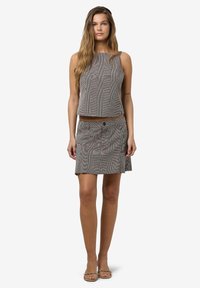 Szürke csíkos ujjatlan felső négyzet alakú dekoltárral, ami egy illeszkedő sziluettel és elülső zsebekkel rendelkező, passzoló miniszoknyával van párosítva.