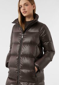 Brauner Puffermantel mit hohem Kragen, Reißverschluss und seitlichen Taschen. Verfügt über ein gestepptes Design mit einer glänzenden, glatten Oberfläche.