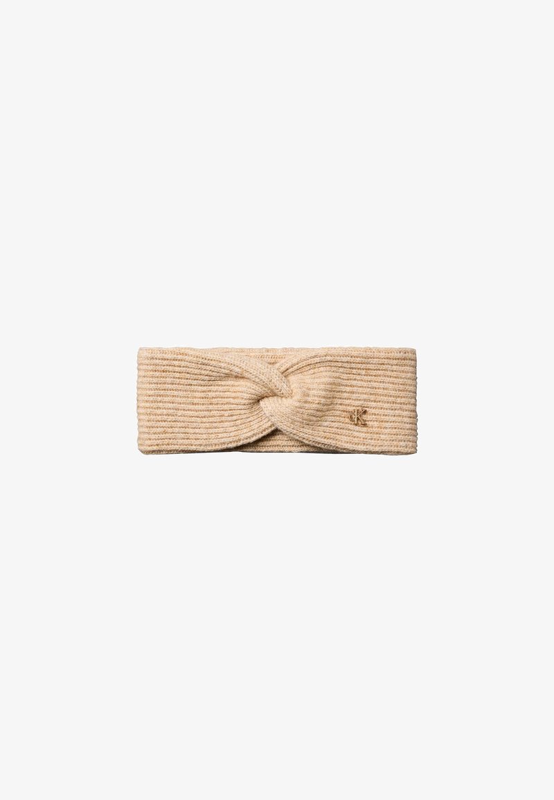 Bandeau beige en maille côtelée avec un nœud torsadé et un petit logo métallique sur un côté.