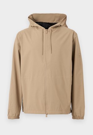 Svetlo rjava jakna s kapuco, sprednja zadrga, elastični manšeti in vrvicami na kapuci, prikazana na enobarvnem ozadju.