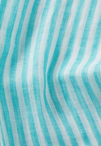 Tessuto leggero con strisce alternate turchesi e bianche. Il materiale ha una texture morbida, creando un aspetto liscio e fluido.