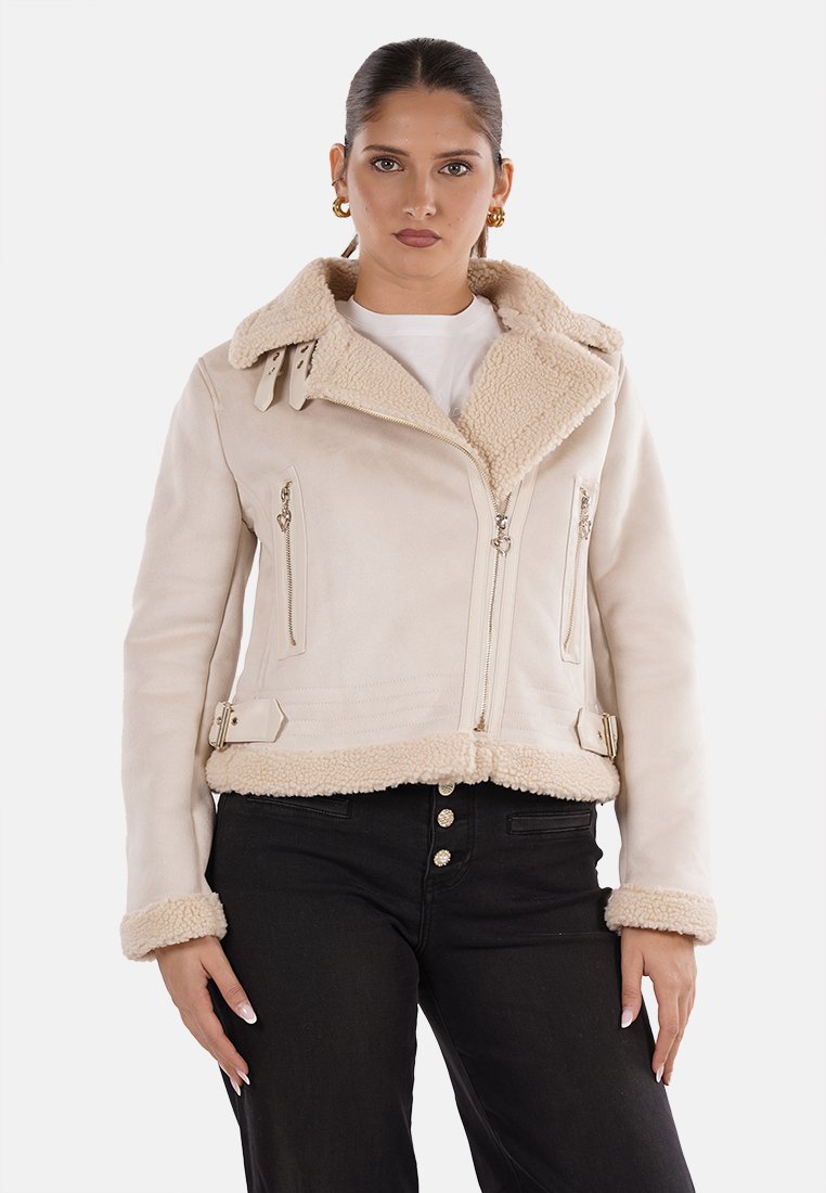 Giacca finta shearling beige, design cropped, con un ampio colletto e tasche con zip. Presenta dettagli con fibbie e una morbida fodera testurizzata.