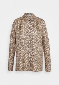 Chemise à manches longues de couleur violet foncé avec un motif floral. Confectionnée en tissu léger, elle présente une patte de boutonnage à l'avant et un col.