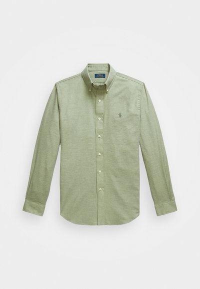 Svetlozelen srajca z dolgimi rokavi in gumbi, s konicasto ovratnico, majhnim vezenim logotipom na prsih in bisernimi gumbi.