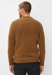 Bruine gebreide trui met een gestructureerd patroon op de bovenrug, geribde manchetten en zoom, gemaakt van een zachte, warme stof.