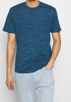 Short-sleeve blue heathered t-shirt made of soft fabric. Features a crew neckline and a relaxed fit. Worn with light denim jeans.