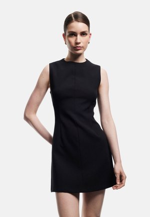 Vestido negro sin mangas con una silueta ajustada, escote redondo y dobladillo a la altura de la rodilla. Fabricado en una tela suave con costuras mínimas.
