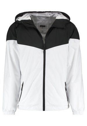 Herrenjacke mit einem schwarzen oberen Bereich und einem weißen unteren Bereich, aus glattem, leichtem Material mit Reißverschlusstaschen und einer Kapuze.