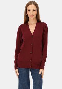 Bordowy sweter na guziki z dzianiny, z dekoltem w serek, długimi rękawami oraz zapinany z przodu. Posiada prążkowany dół i mankiety, gładką fakturę oraz klasyczny design.