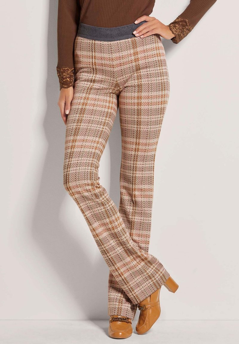 Brown plaid flared pants featuring a textured fabric with hues of pink and orange, and a solid gray waistband. Notable pattern accents throughout.