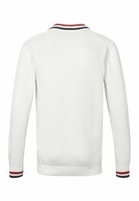 Valkoinen neulepaita, jossa on ribattu kaula-aukko punaisilla ja laivastonsinisillä raidoilla. Pitkät hihat ja vastaavat raidoitetut hihansuut. Takana näkyvä näkymä.