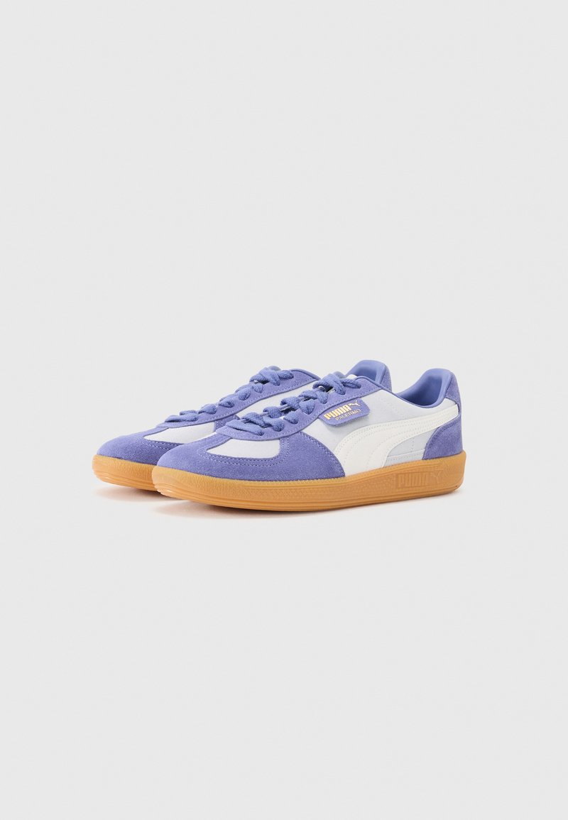 Sneaker viola e bianca con una tomaia in suede e mesh, dotate di una suola in gomma beige e lacci rotondi, accentuate dal marchio PUMA.