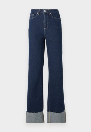 Donkerblauwe denim flare jeans met een hoge taille, voorzien van een ruwe zoom en een lichtere denim manchet bij de enkels. Zilveren sluiting met knop.