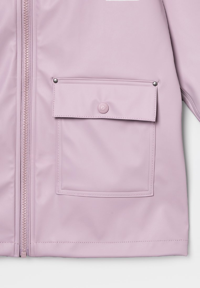 Helle lila Jacke mit Vorderreißverschluss und großer rechteckiger Tasche, die mit einem Druckknopf und zwei Nieten auf dem Deckel versehen ist.