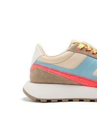 Baskets de sport avec une tige synthétique beige, des accents bleu et rose, une texture en daim et une semelle en caoutchouc grise légèrement talonnée.