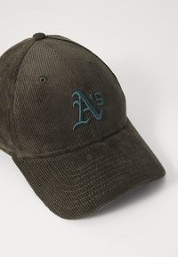 Dark green corduroy baseball cap featuring a textured surface and embroidered "A's" logo in teal on the front.