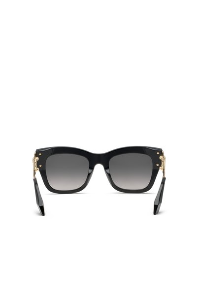 Lunettes de soleil noires à monture carrée avec verres foncés dégradés et détails dorés aux charnières sur fond blanc.