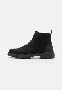 Stivaletti alla caviglia in suede nero con punta arrotondata, design con lacci, suola in gomma con battistrada e una linguetta sul tallone per una facile calzata.