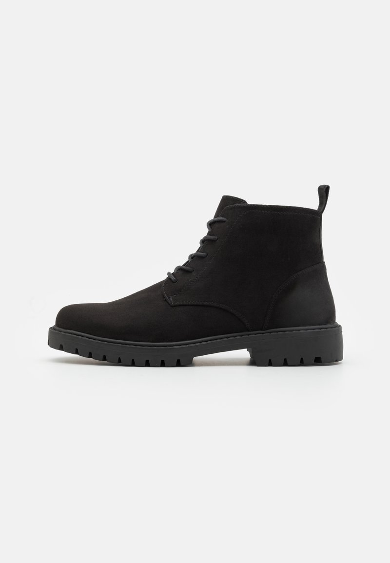 Stivaletti alla caviglia in suede nero con punta arrotondata, design con lacci, suola in gomma con battistrada e una linguetta sul tallone per una facile calzata.