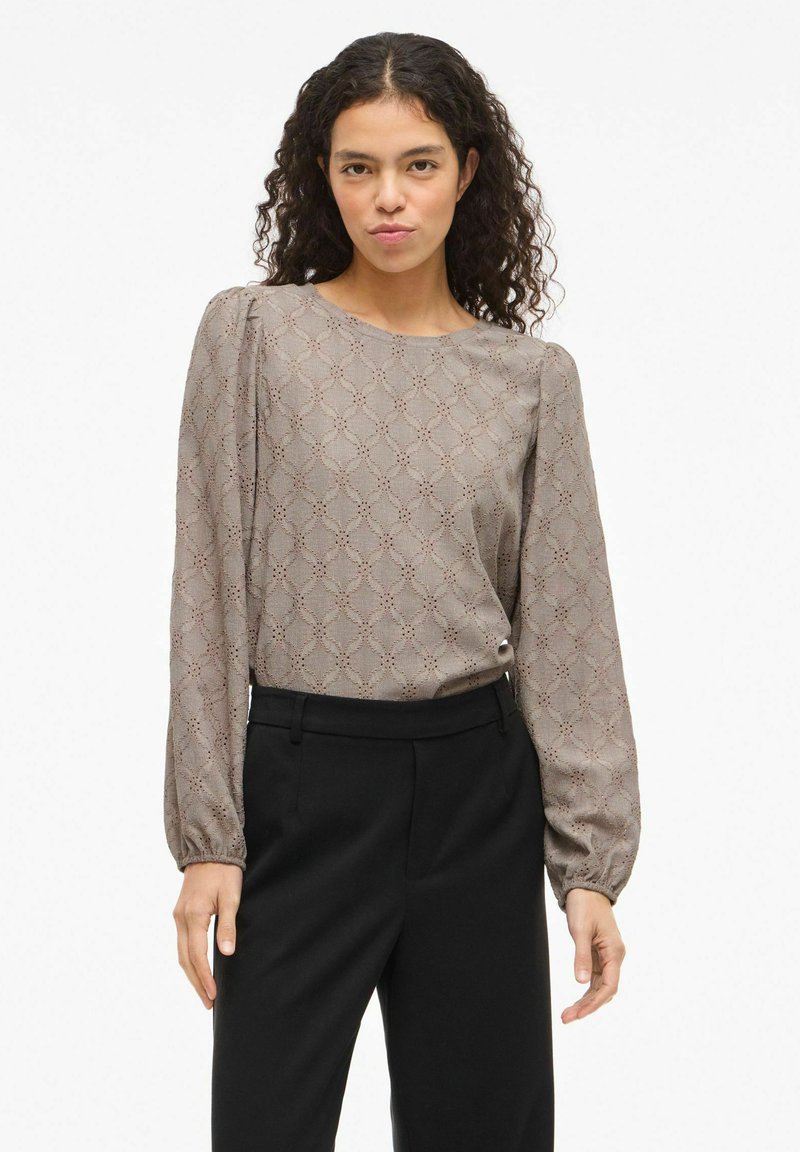 Ilgas rankovėmis šviesiai taupe spalvos palaidinė su deimanto raštu, apvaliomis kaklo iškirpte ir surinktomis rankovėmis. Derinama su juodomis kelnėmis.