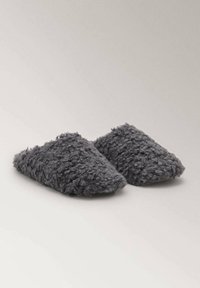 Fluffy grijze instapslippers met een zachte, gestructureerde oppervlak en een afgerond ontwerp van de teen. Geen zichtbare bevestigingen of patronen.