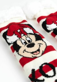 Calzini a righe rosse e bianche con un motivo a maglia di un personaggio dei cartoni animati con un fiocco, morbidi polsini bianchi e la parola "AMORE" in nero.