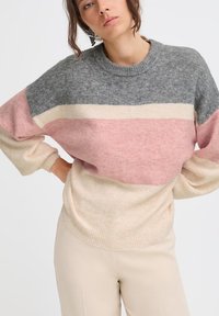 Maglione oversize grigio, rosa e crema. Realizzato in materiale morbido con maniche larghe, vita a coste e design a blocchi di colore orizzontali.