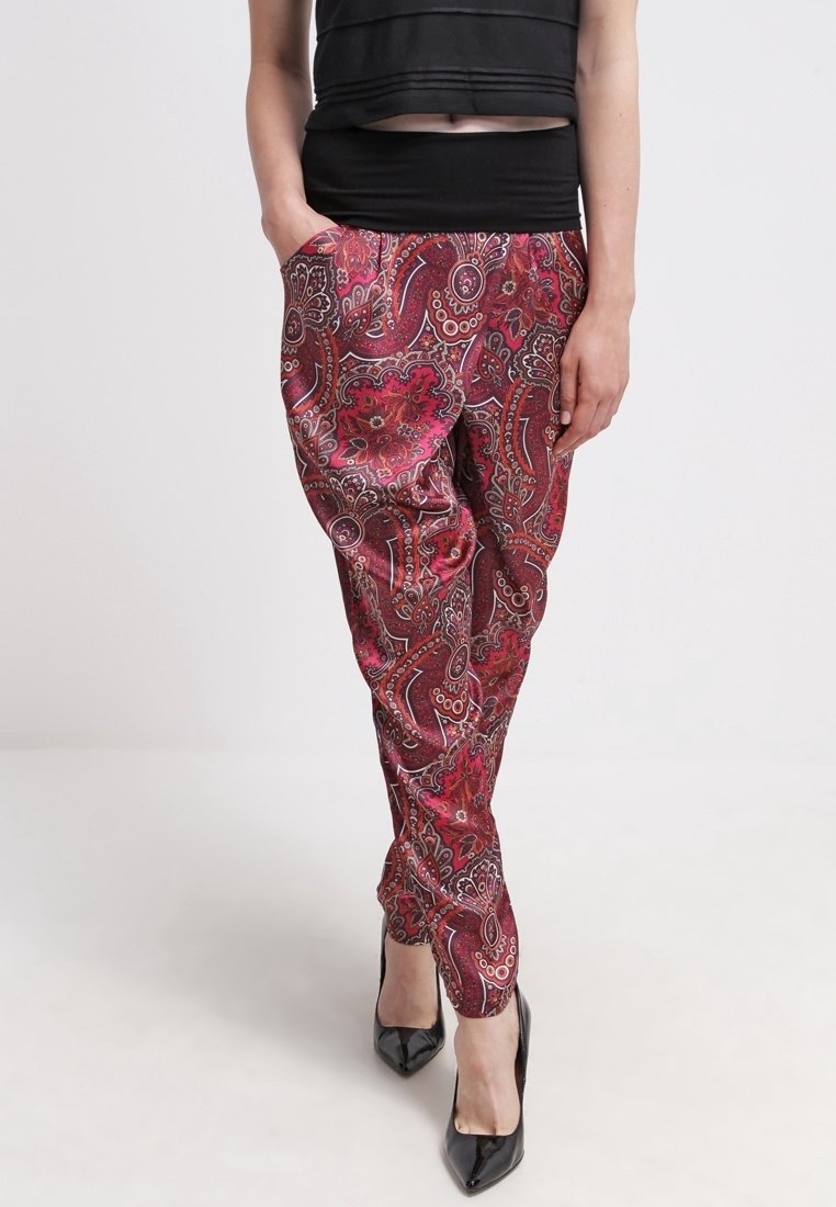 Röda byxor med paisleymönster i mjukt tyg, med resårmidja, sidofickor och avsmalnande passform. Matchas med svarta klackar.